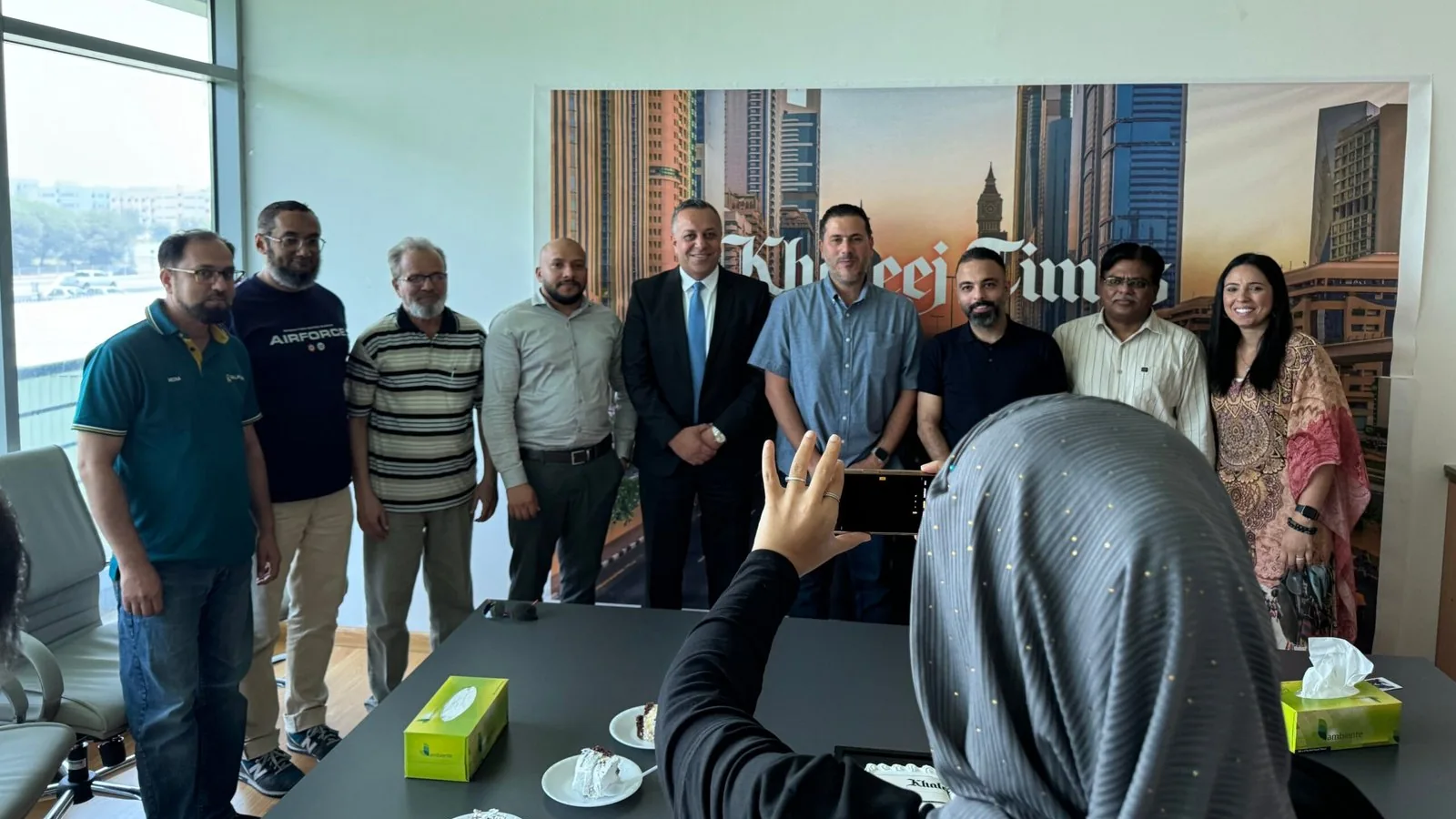 PRO TECHnology and Khaleej Times teams together in front of the Khaleej Times backdrop at the newspaper's Dubai office after the Dropbox deployment