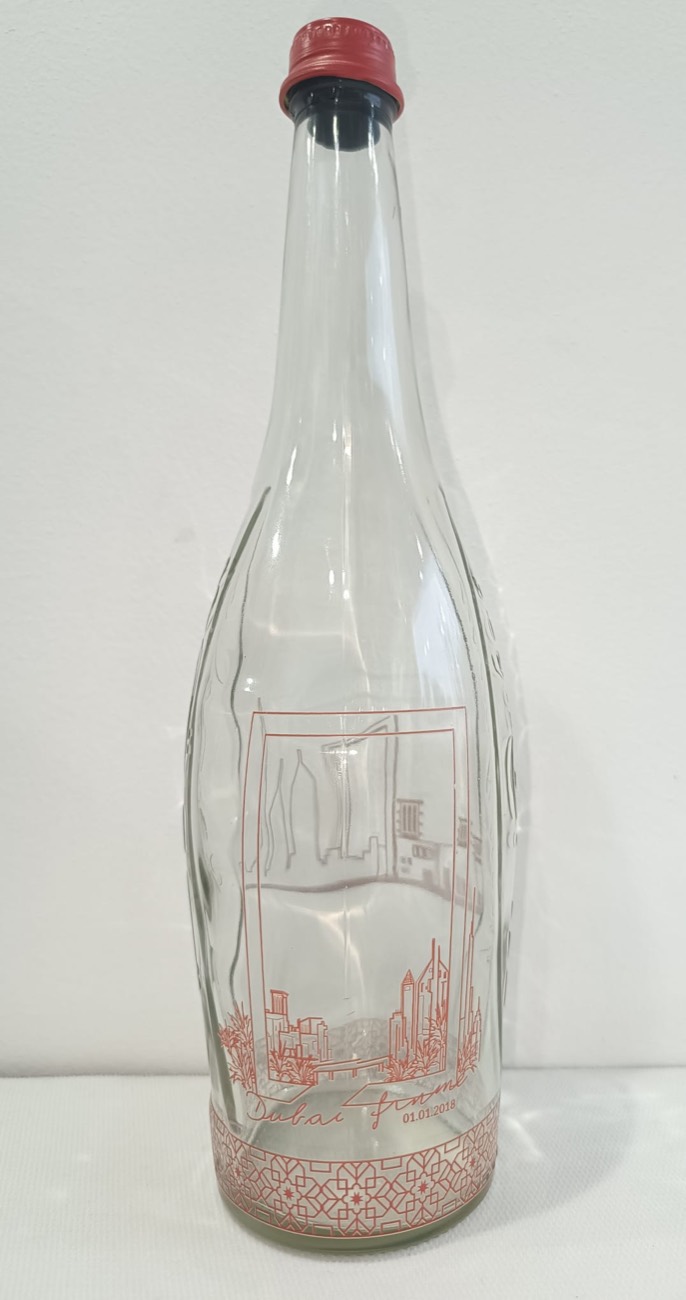 Clear glass bottle printed directly with fine line artwork and a patterned band, the unprinted glass still visible through the design