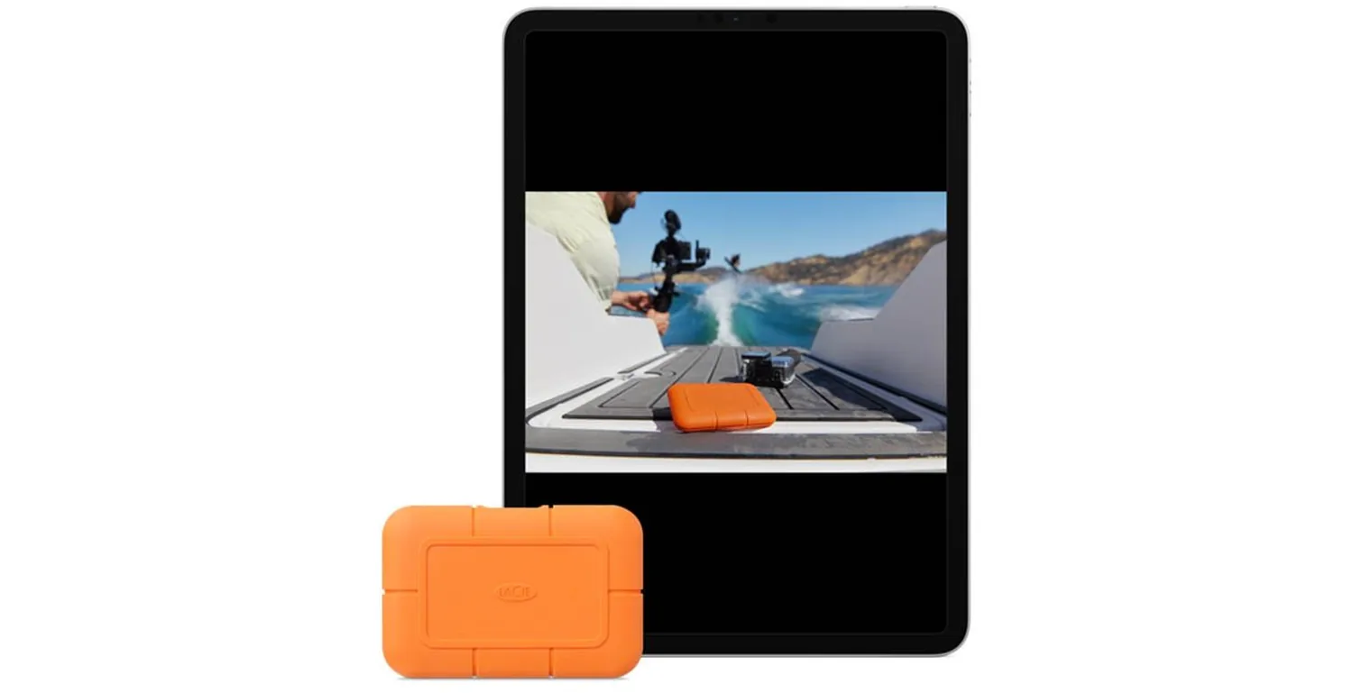 LaCie Rugged SSD in its orange bumper beside an iPad playing back footage of a boat shoot: LaCie's own image of the Rugged SSD on location