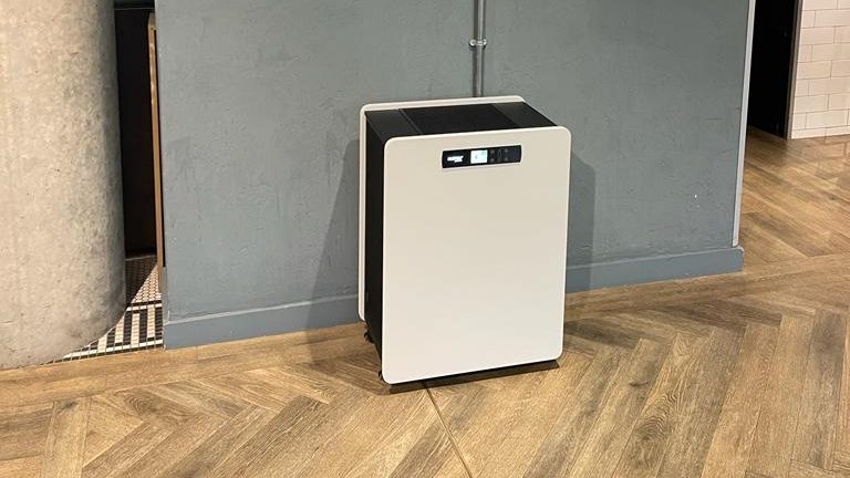 جهاز تنقية الهواء MedicAir Pro Max على عجلات أمام جدار رمادي