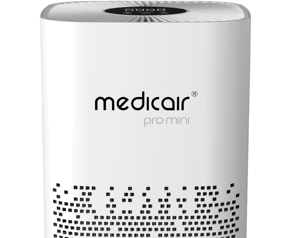 Close-up of the MedicAir Pro Mini's white casing showing the recessed touchscreen control panel on the top surface and the square perforations of the intake grille below the brand mark