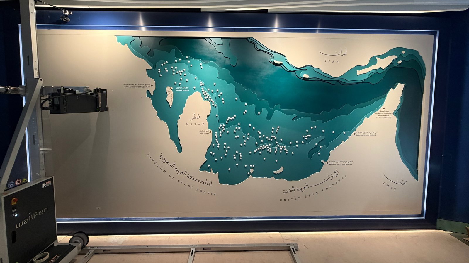 A wallPen printer on floor rails beside an installed, layered museum map panel