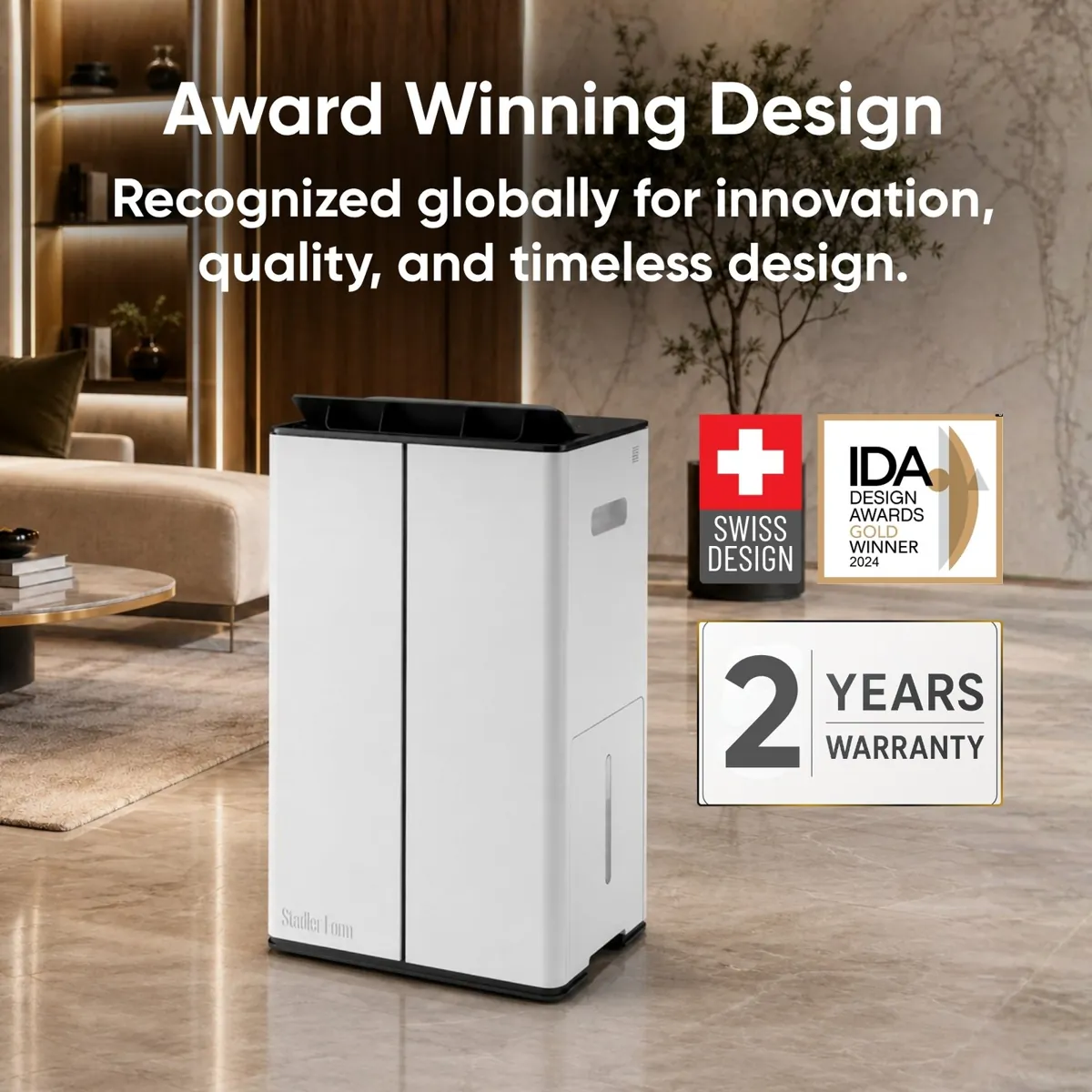 White Stadler Form Lukas dehumidifier in a living room beside Swiss design, IDA Design Awards Gold Winner 2024 and 2 years warranty badges