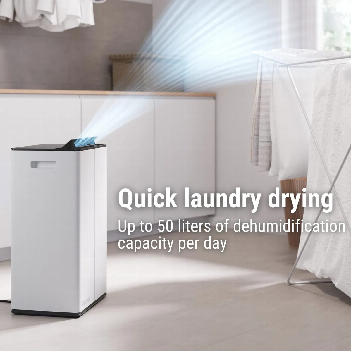 Stadler Form Lukas Pro in a laundry room blowing air from its top outlet towards a rack of drying washing