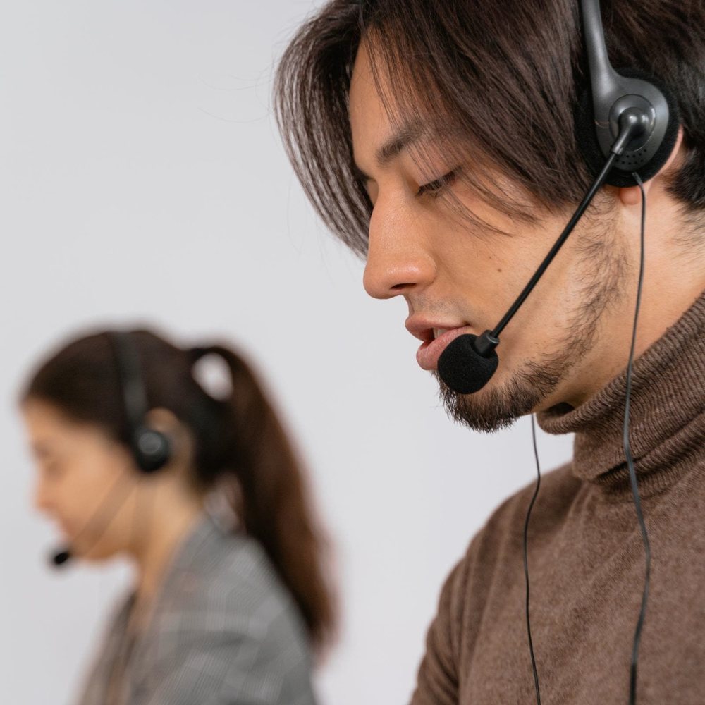 Two customer service agents wearing headsets on calls
