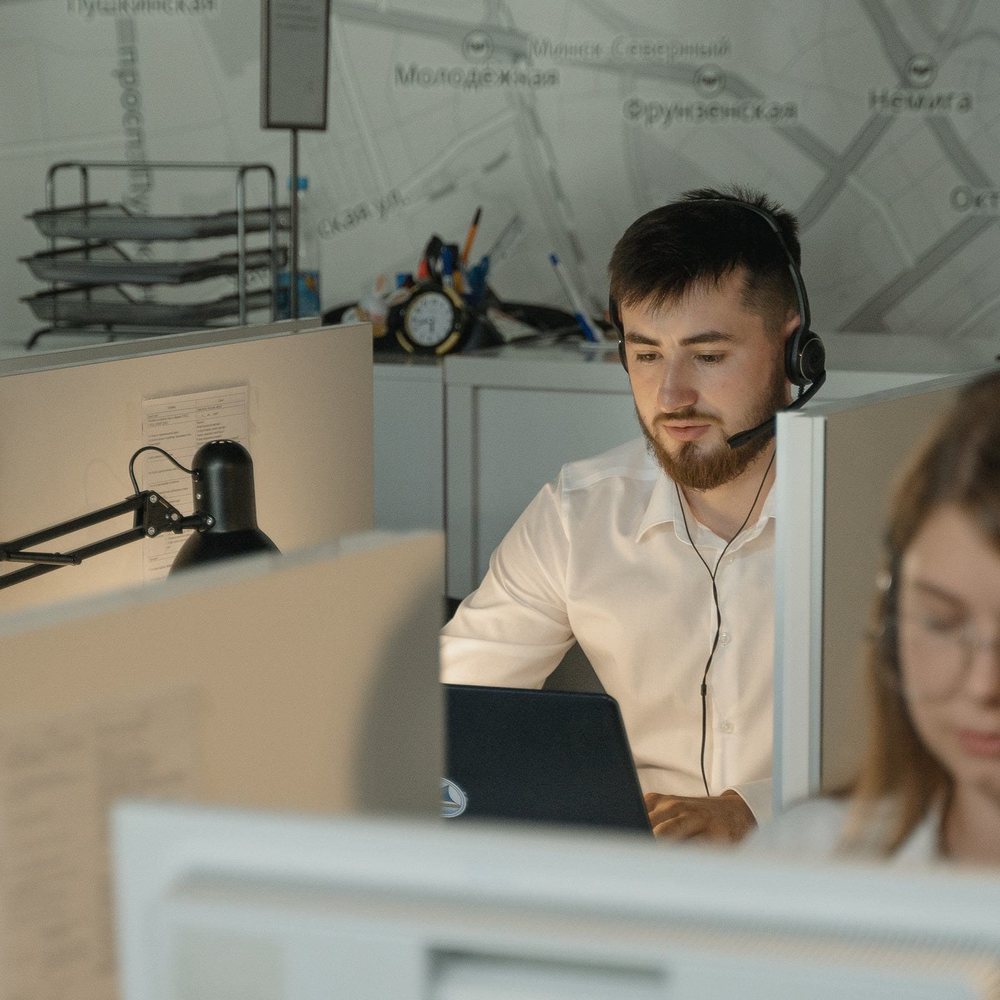 A customer service agent with a headset working at a desk