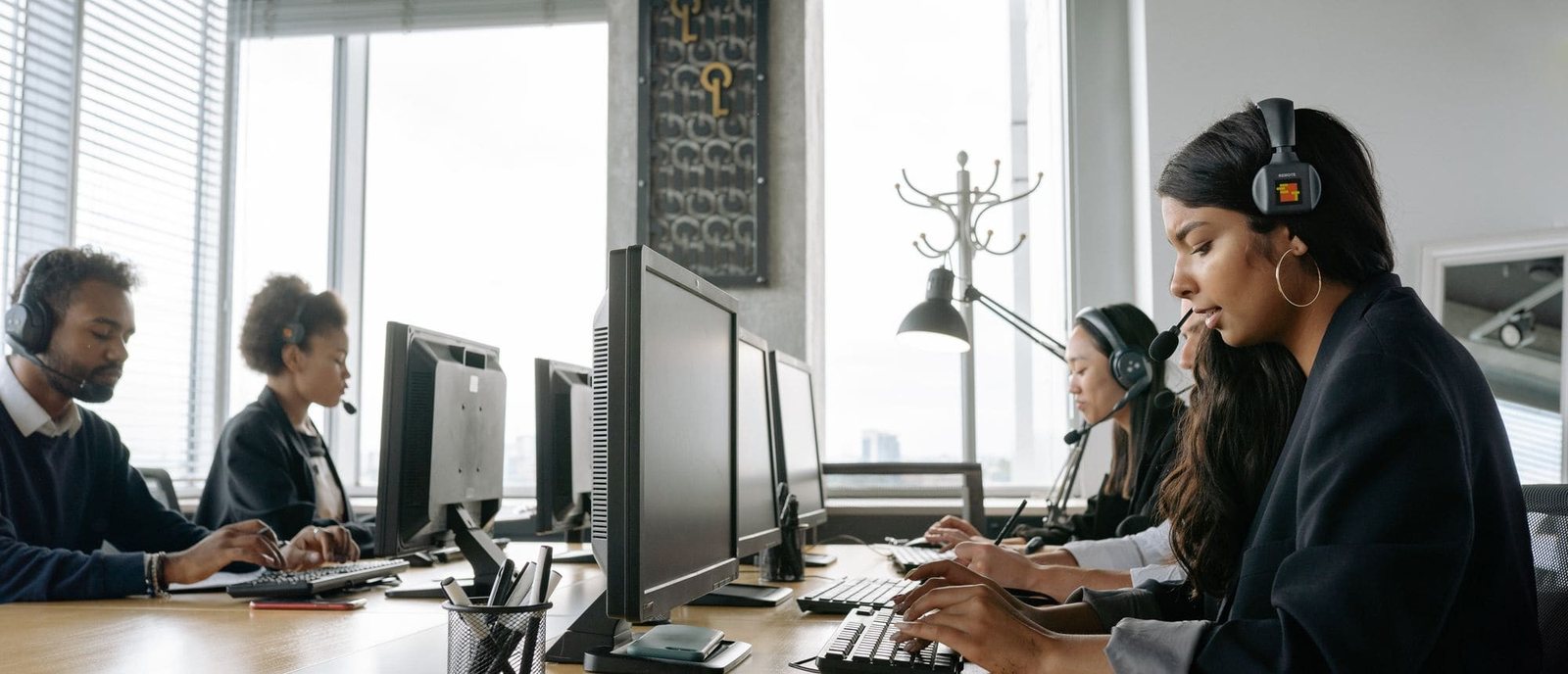 Customer service agents with headsets handling business calls at their desks
