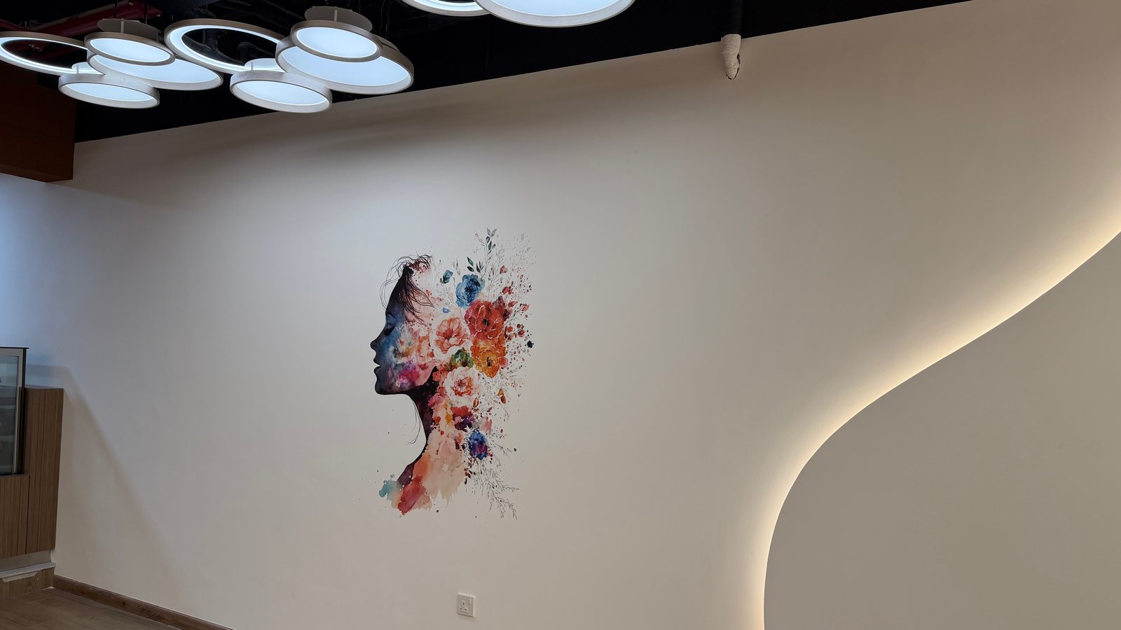 Floral profile artwork printed by a wallPen on a curved gym reception wall in Abu Dhabi