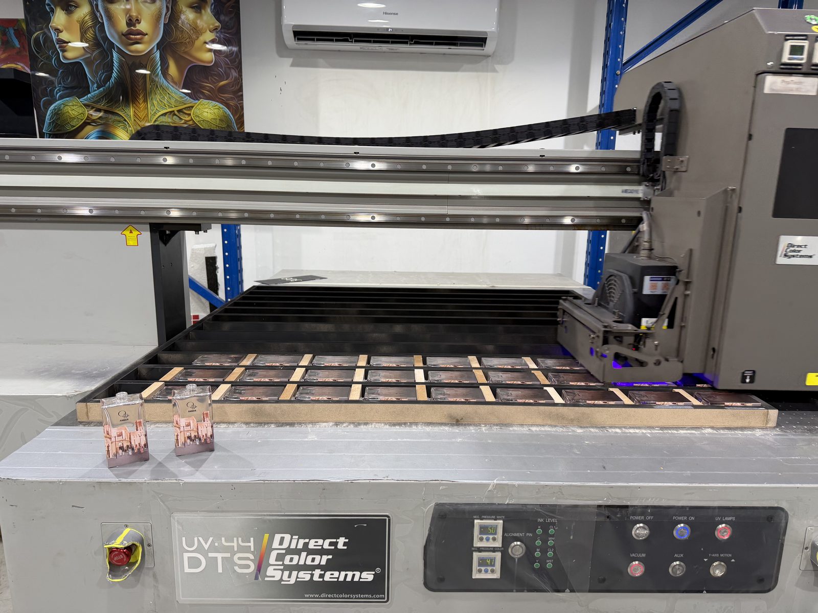 Flat glass perfume bottles held in a printing jig on a Direct Color Systems UV flatbed at Sun Studio, a UV printing company in Al Quoz, Dubai